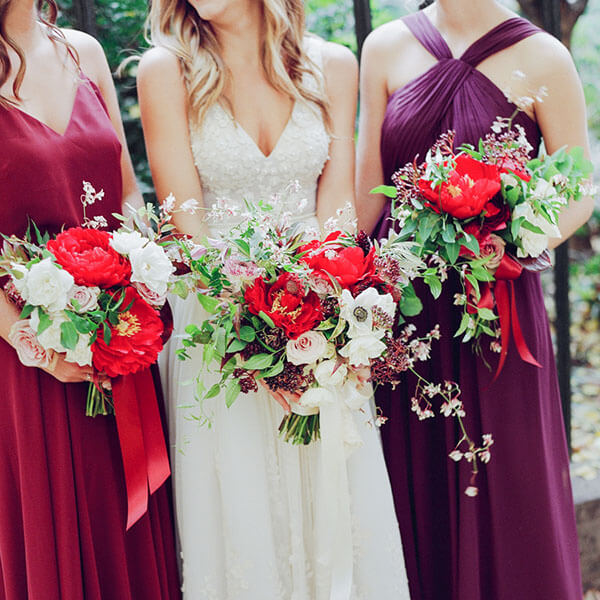 bride and bridesmaids with red peony bouquets|pink peonies glass julep cup vase|||